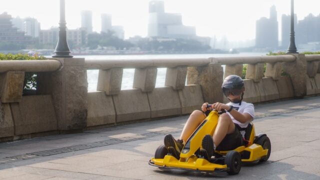 a young boy is riding a go - kart on a bridge