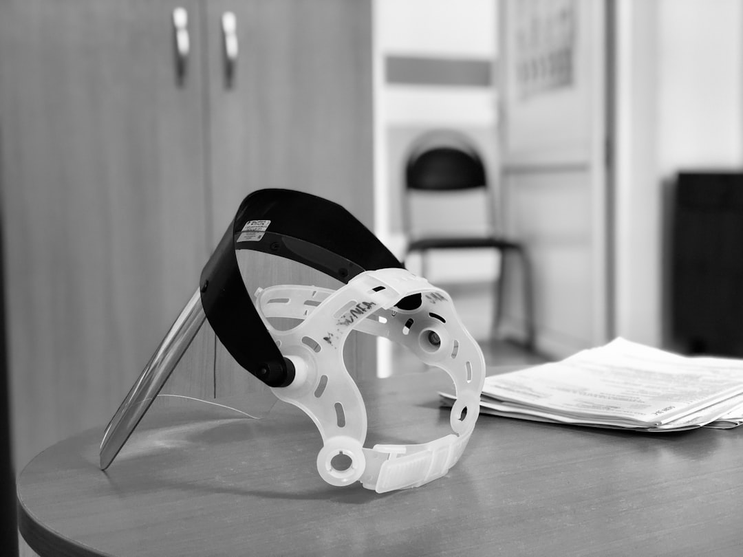 A black and white photo of a helmet on a table — Best Karting Neck Brace