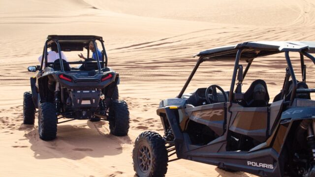 a couple of vehicles that are in the sand