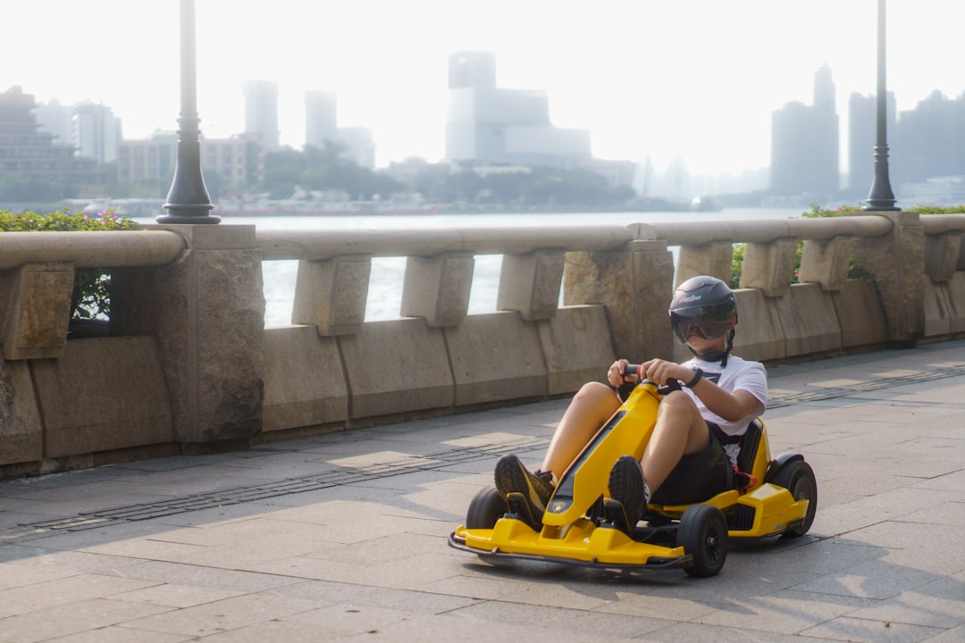 a young boy is riding a go - kart on a bridge