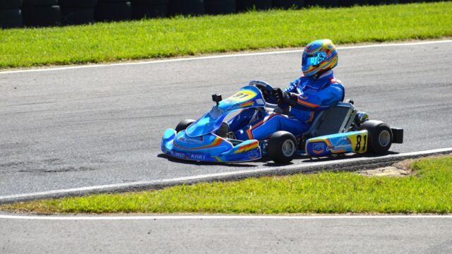 A blue go-kart races on a track