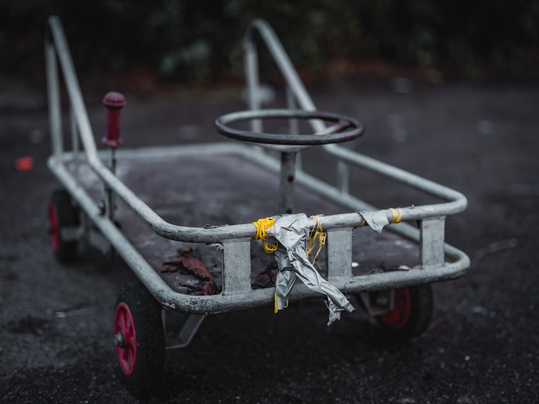 A metal cart with pink wheels and a steering wheel