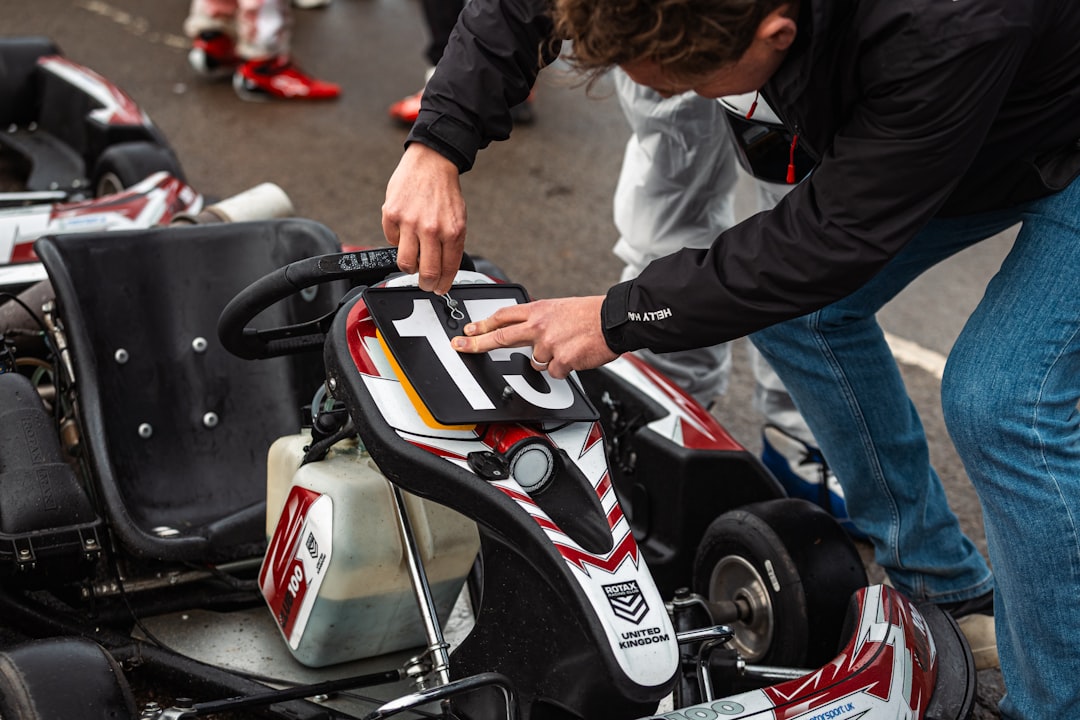 Person adjusting a go-kart with number 13.