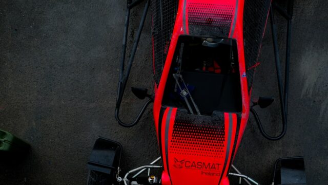Red go-kart with black accents on dark surface