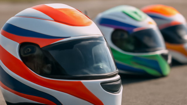 A clean, realistic editorial photograph of karting helmets, natural light, no text or logos.
