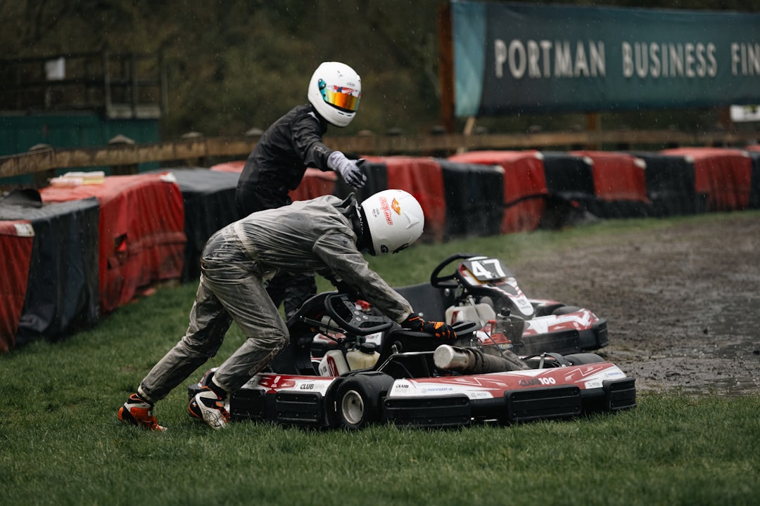 Two racers push a go-kart on a track — Karting Rain Suits