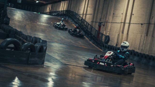 a group of people riding go karts in a race track