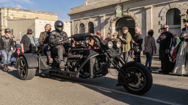 A group of men riding motorcycles down a street