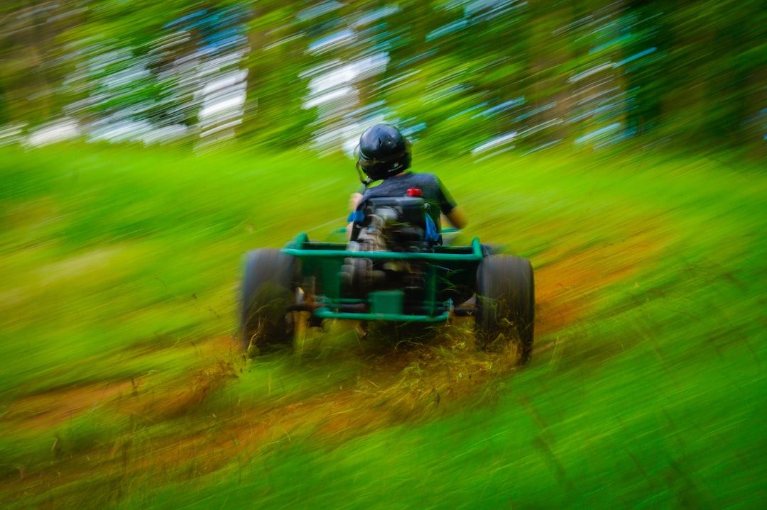 Person riding a go-kart down a grassy hill