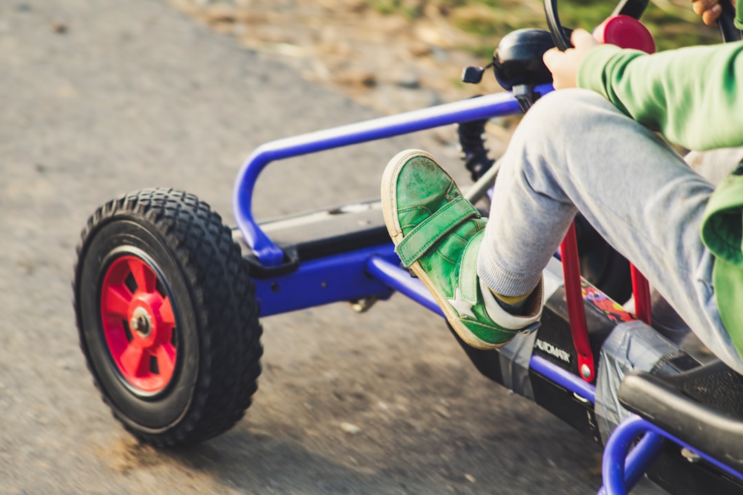 child riding blue and black ride on toy car