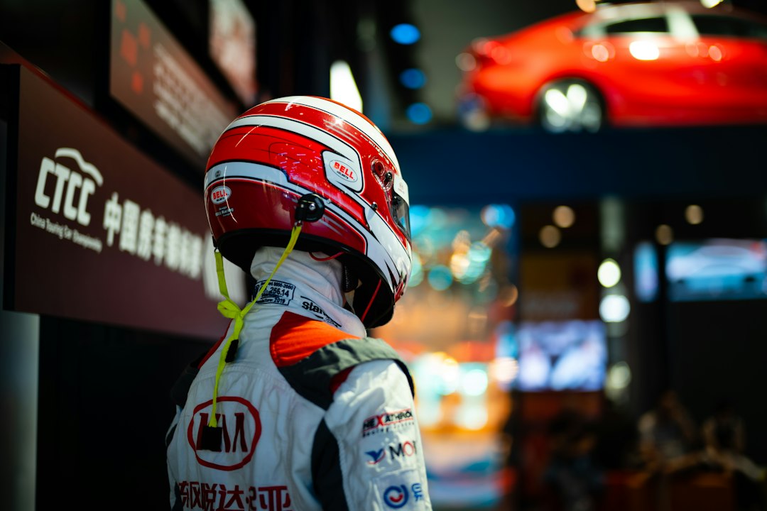 Racing driver in helmet and suit looking forward