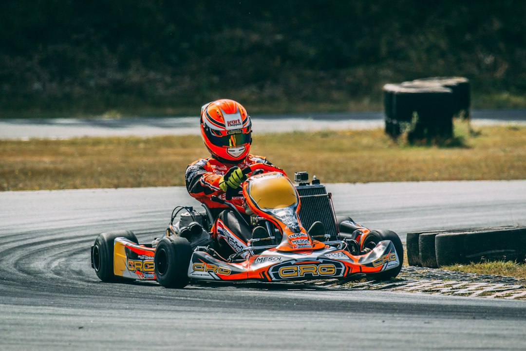 A person riding a go-kart on a race track — Go Kart Brake Bleeding
