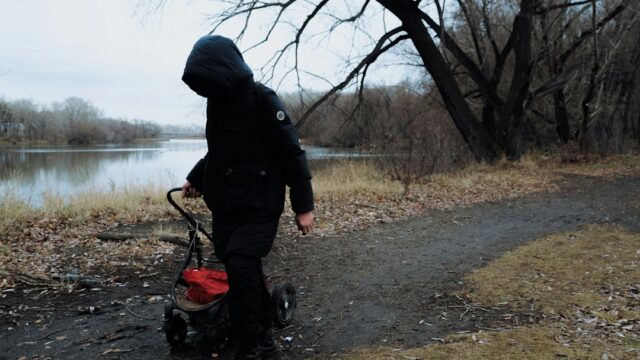 Person with stroller walks on path near river — Pedal Power Go-Kart