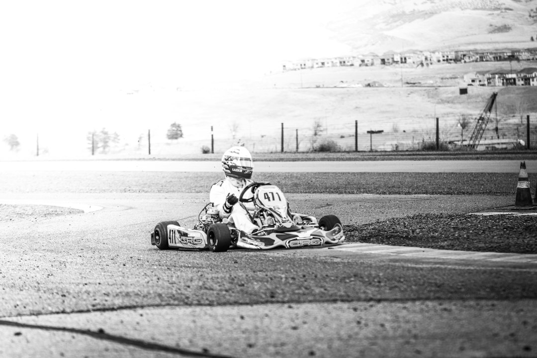 Grayscale photo of man riding on go-kart — Racing Go-Kart Parts