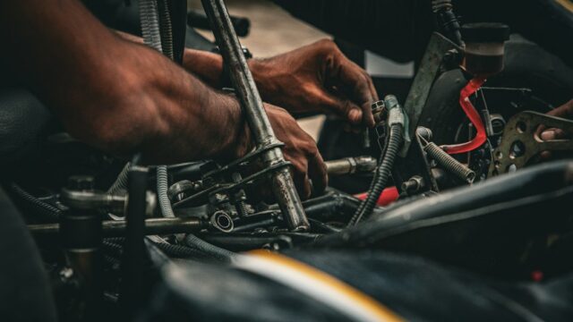 Hands of a person working on the mechanical components of a go-kart — Racing Go-Kart Stands
