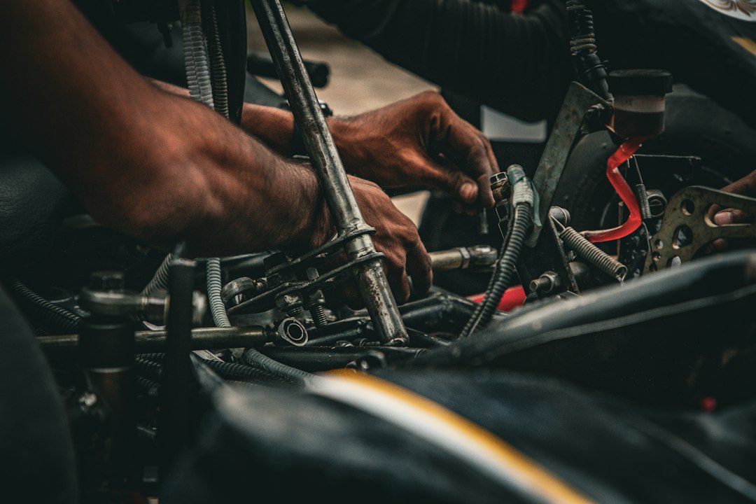 Hands of a person working on the mechanical components of a go-kart — Racing Go-Kart Stands