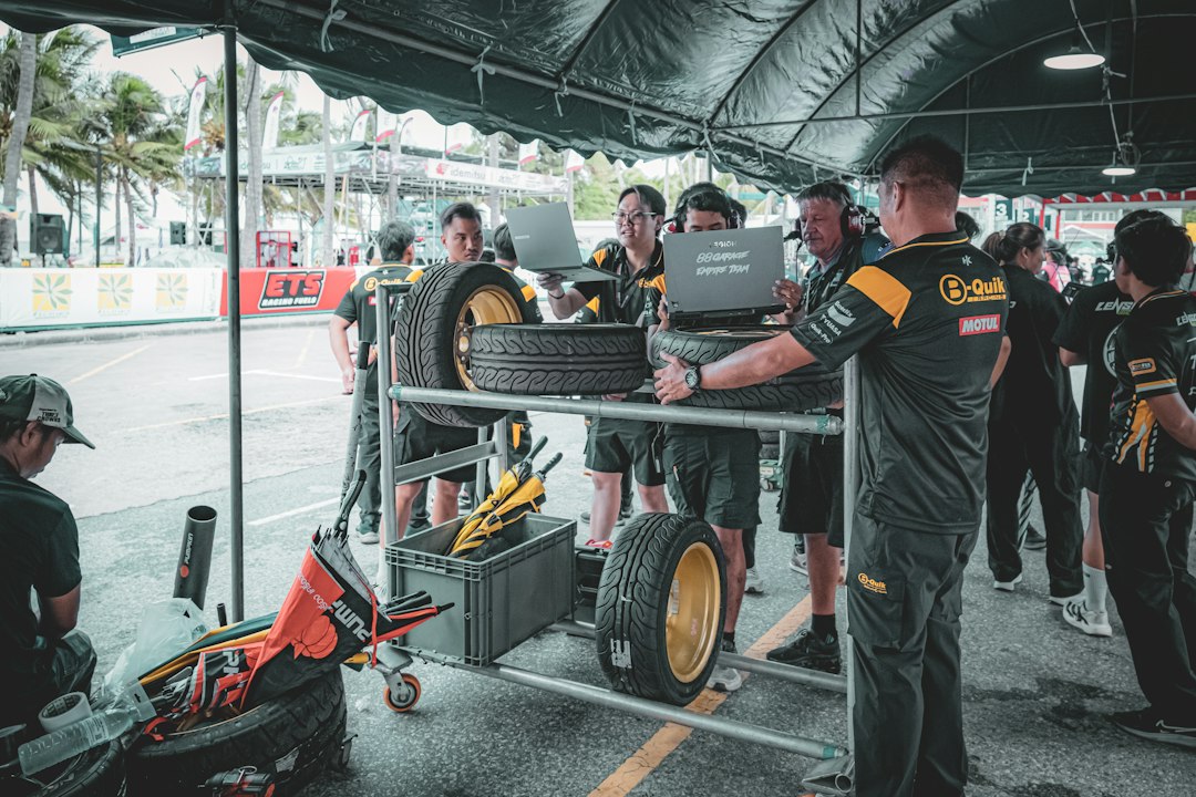 Race pit crew preparing tires with laptops — Used Racing Go-Kart